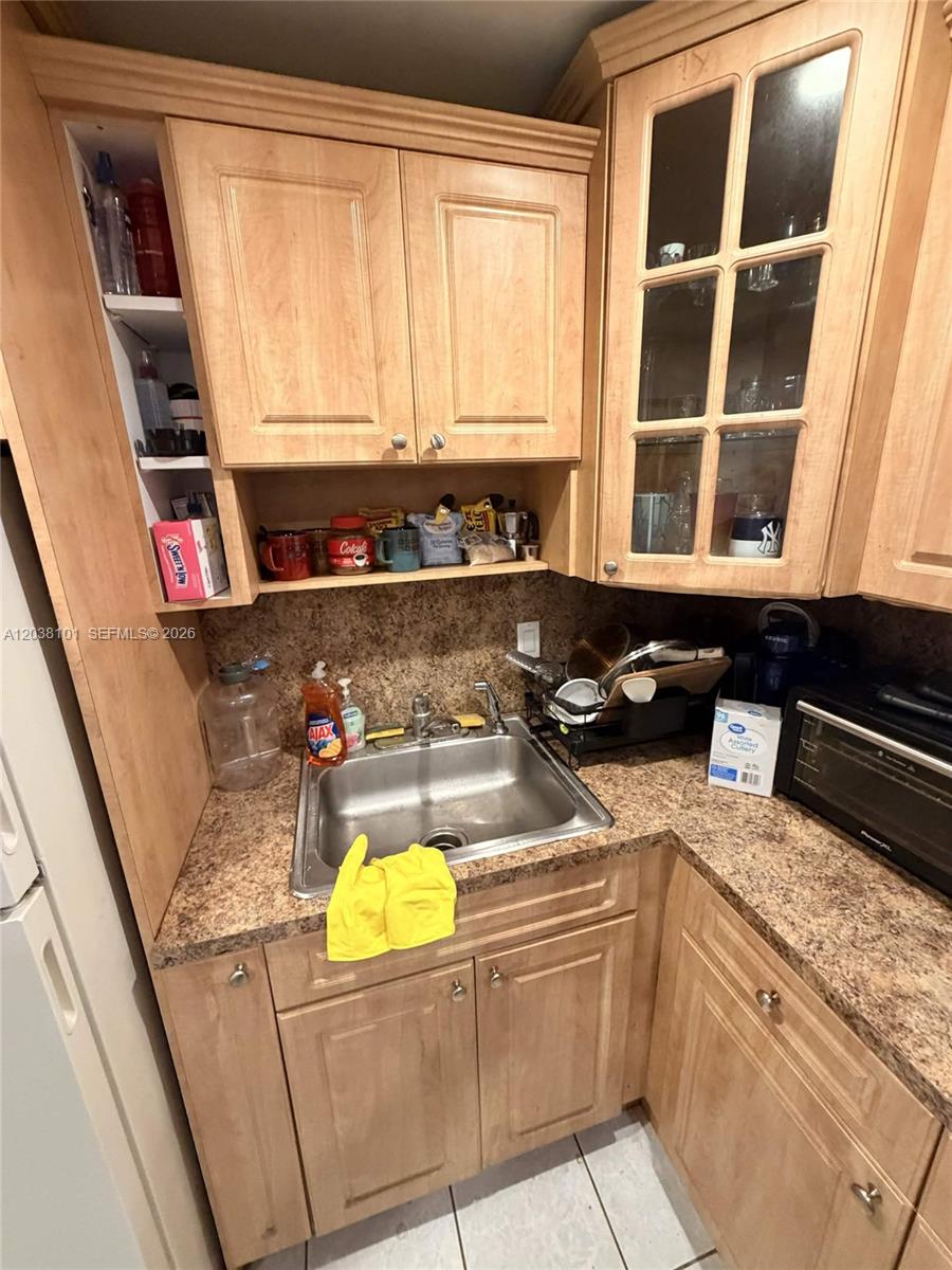 A kitchen features light wood cabinets, a stainless steel sink, and speckled laminate countertops — 9974 SW 88th St # 1011, Miami FL 33176, MIAMI, FL