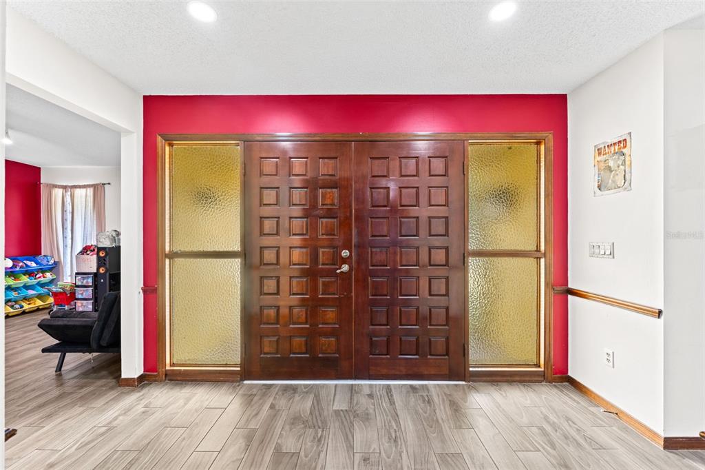 A foyer features a double wooden door with glass side panels and red accent walls — 3852 S LAKE ORLANDO PARKWAY, ORLANDO, FL
