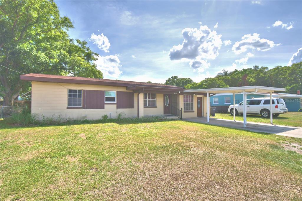 A single-story house with a carport and a large front lawn under a blue sky — 3006 ELM STREET, WINTER HAVEN, FL
