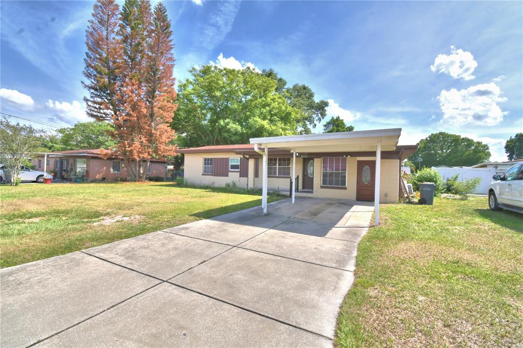 A single-story house with a concrete driveway and a covered carport under a blue sky — 3006 ELM STREET, WINTER HAVEN, FL