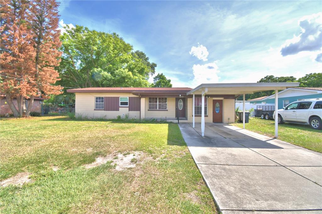 A single-story house with a beige exterior, a brown roof, and an attached carport — 3006 ELM STREET, WINTER HAVEN, FL