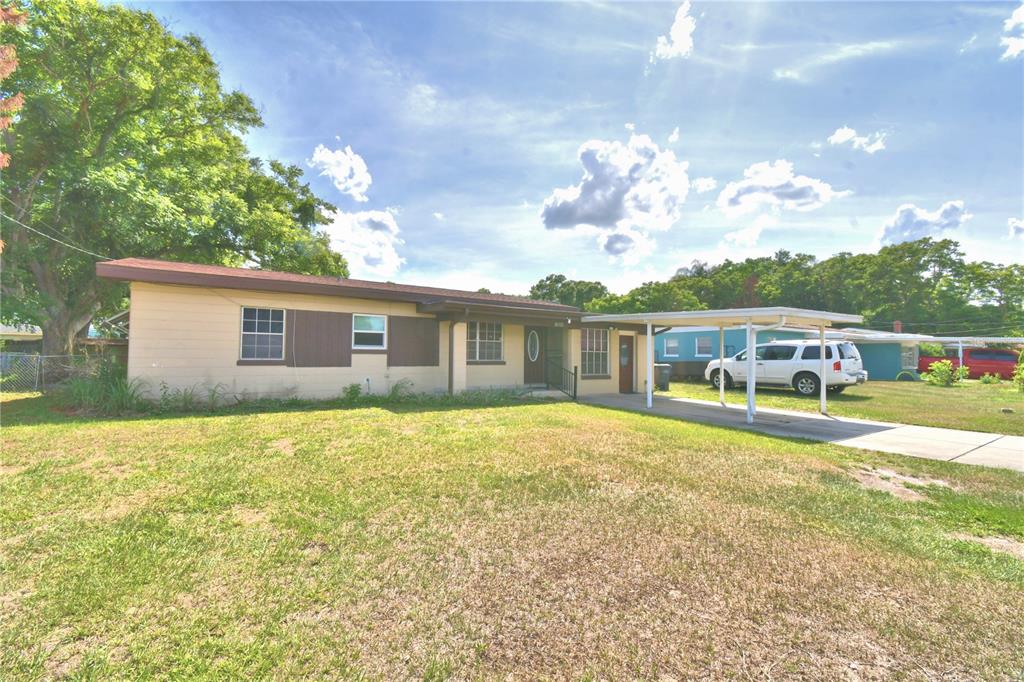 A single-story house with a beige exterior, a brown roof, and an attached metal carport — 3006 ELM STREET, WINTER HAVEN, FL