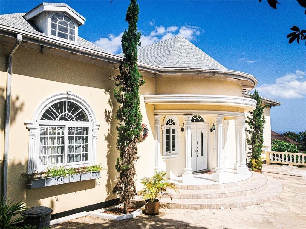 A beige house exterior features a rounded entryway with white columns and a large arched window — 368 Hartsfield N Hartsfield Ironshore Drive, FL