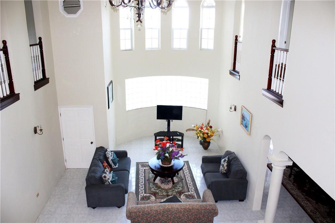 A high-angle view of a two-story living room with a glass block wall and chandelier — 368 Hartsfield N Hartsfield Ironshore Drive, FL