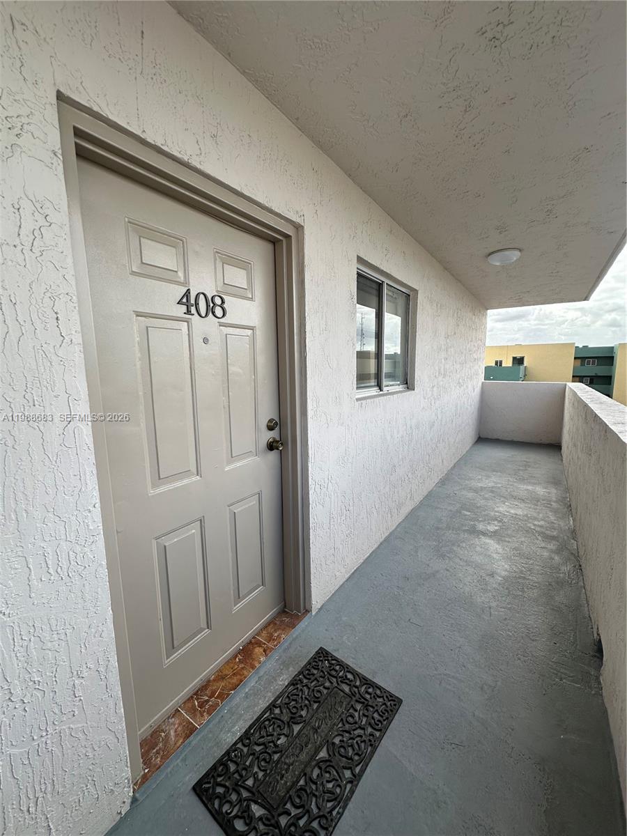 An exterior view of a residential apartment door labeled 408 on a concrete walkway — 6091 W 22nd Ct # 408, Hialeah FL 33016, HIALEAH, FL