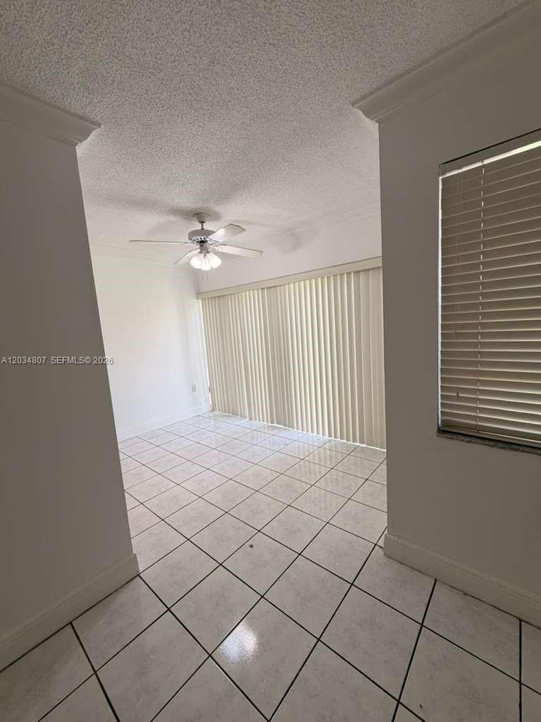 A room with white tiled floors, a ceiling fan, and vertical blinds covering a sliding door — 9311 SW 4th St # 117B, Miami FL 33174, MIAMI, FL