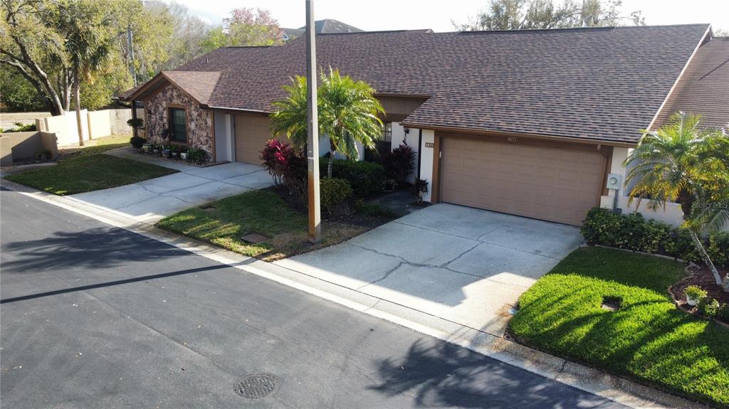An exterior view of a single-story duplex with two garage doors and a shared driveway — 4075 SHORESIDE CIRCLE, TAMPA, FL