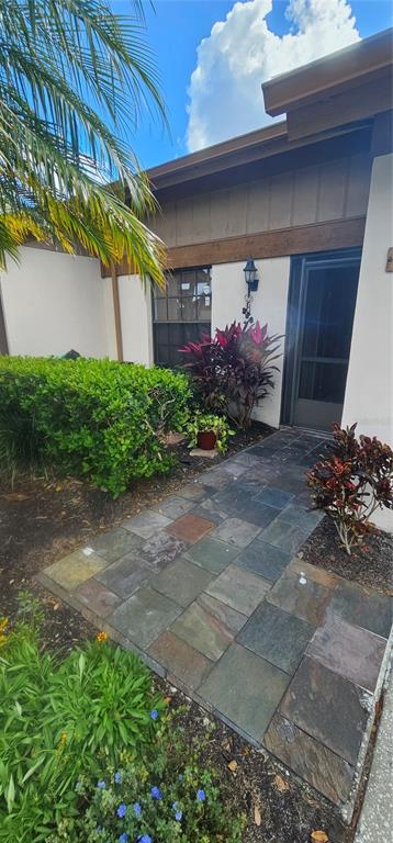 A stone walkway leads to the front entrance of a home with a landscaped yard — 4075 SHORESIDE CIRCLE, TAMPA, FL