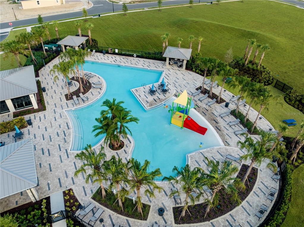 An aerial view of a community swimming pool with a slide and palm trees — 7272 ROLLING LEAF ROAD, GROVELAND, FL
