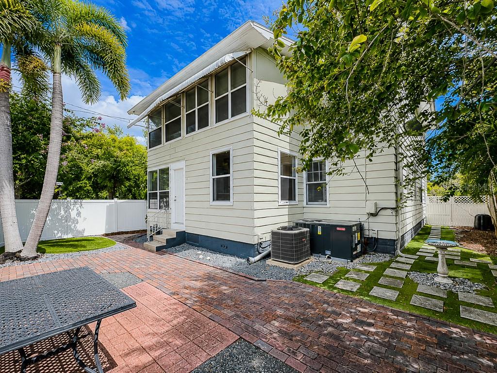 A two-story house with light siding, a brick patio, and a fenced backyard — 400 20TH STREET N, ST PETERSBURG, FL