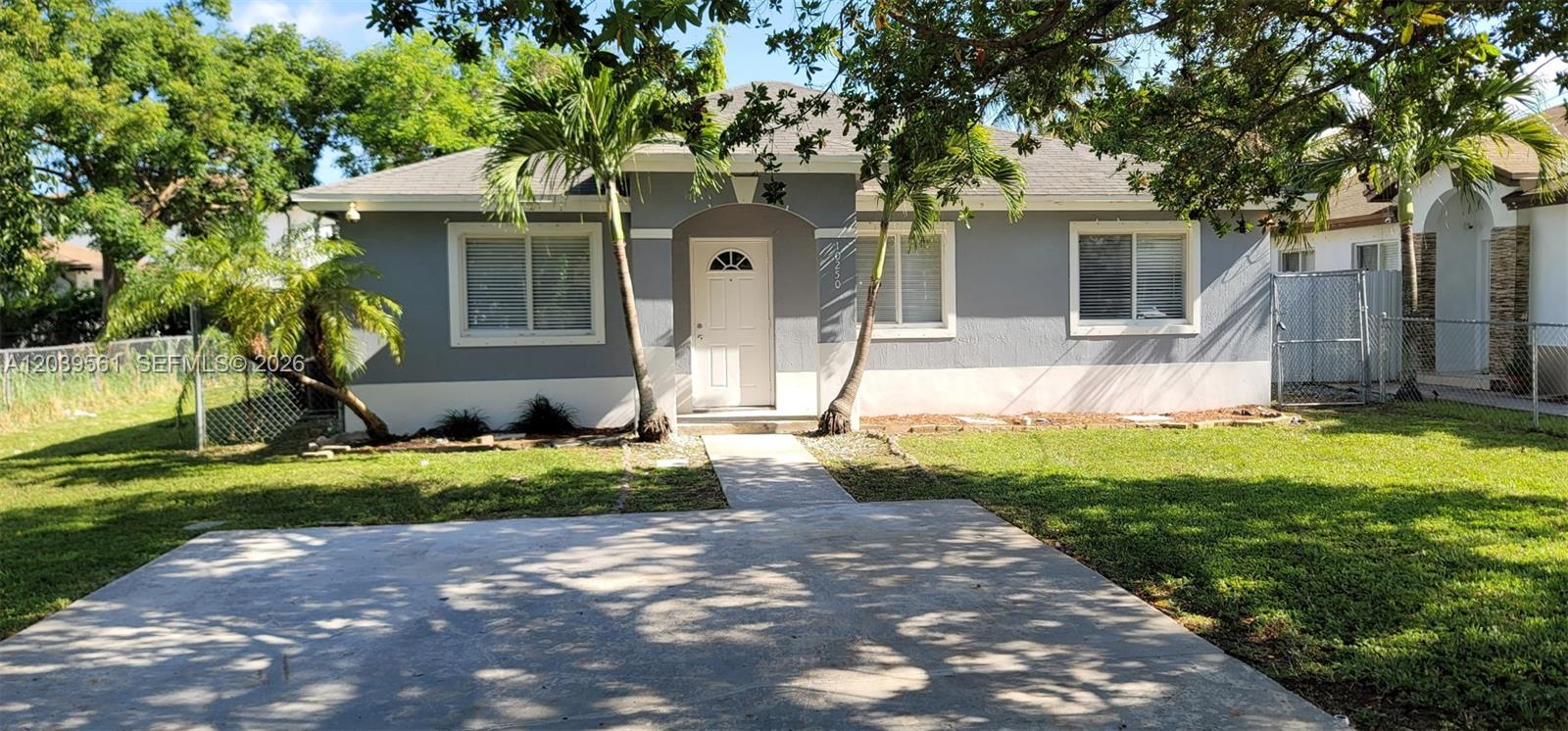 A single-story gray house with a white door, concrete walkway, and palm trees in front — 10250 SW 173rd Ter, Miami FL 33157, MIAMI, FL