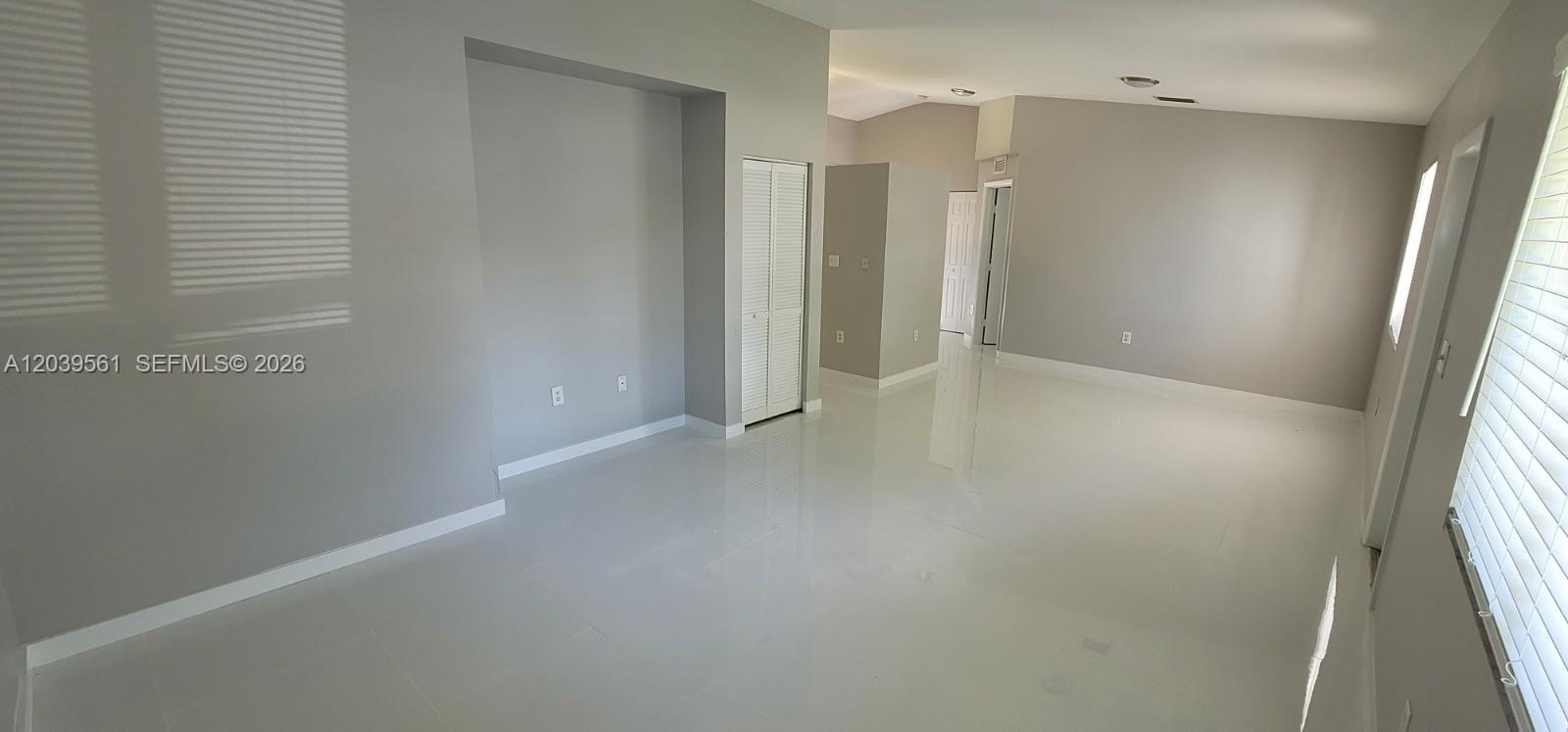 An empty room features light gray walls, white tile flooring, and a recessed wall area — 10250 SW 173rd Ter, Miami FL 33157, MIAMI, FL