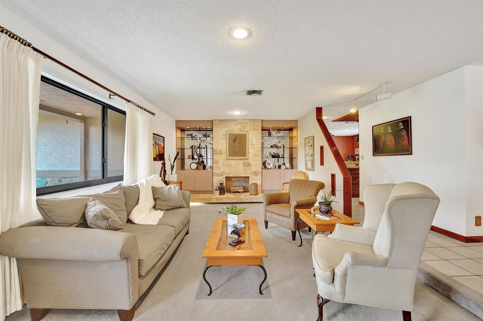 A living room features a stone fireplace, built-in shelving, carpeted floors, and traditional furniture — 3951 SW 137th Avenue, Miramar FL 33027, MIRAMAR, FL