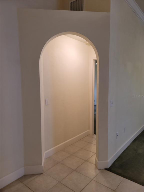 An arched doorway leads into a tiled hallway with a view of an interior room — 6312 NW 109TH PLACE, ALACHUA, FL