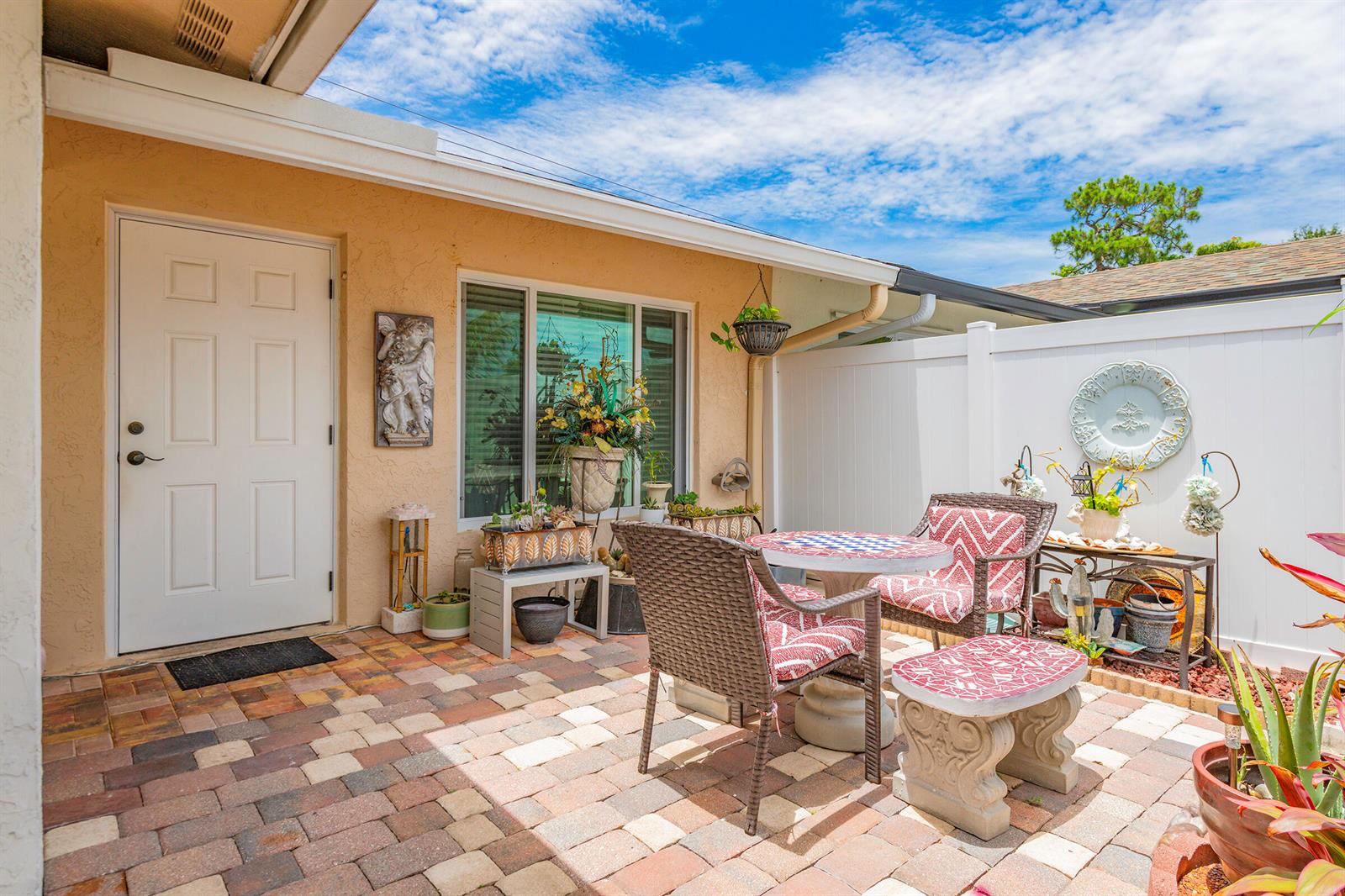A patio with a brick floor, outdoor furniture, and a white privacy fence — 4431 SE Village Road, Stuart FL 34997, STUART, FL