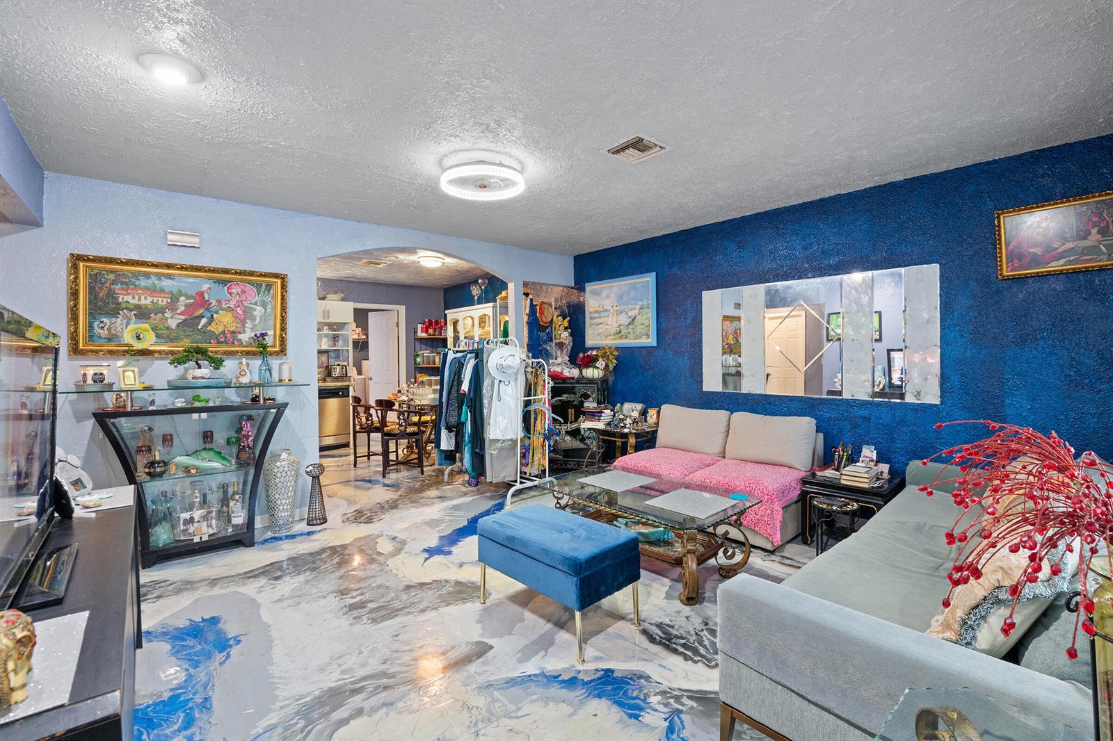 A living room features blue textured walls, a marbled epoxy floor, and two sofas — 4431 SE Village Road, Stuart FL 34997, STUART, FL