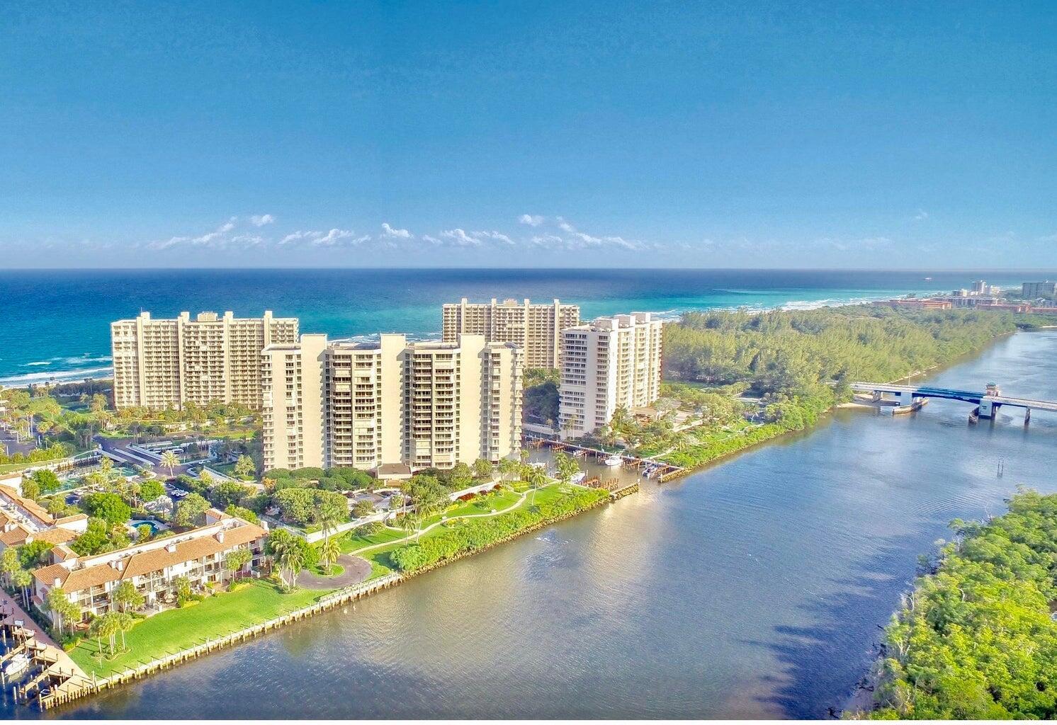 An aerial view shows high-rise apartment buildings situated between a river and the ocean — 4201 N Ocean Boulevard # 1405, Boca Raton FL 33431, BOCA RATON, FL
