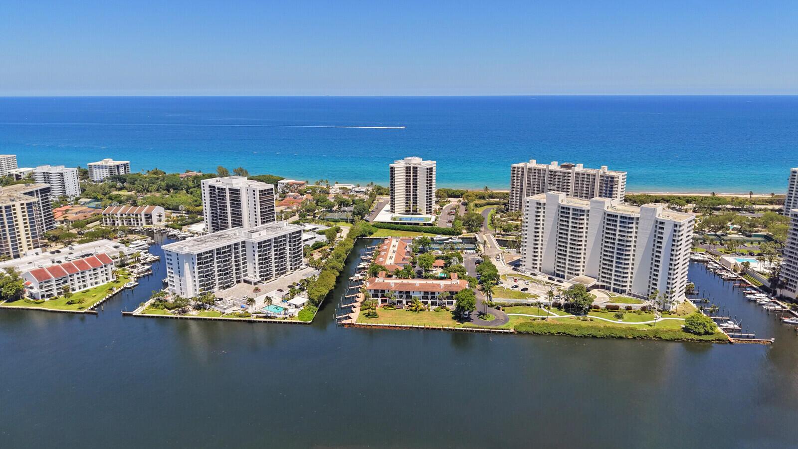 Aerial view of waterfront apartment buildings and boat docks along a canal near the ocean — 4201 N Ocean Boulevard # 1405, Boca Raton FL 33431, BOCA RATON, FL
