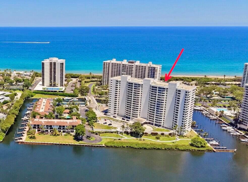 An aerial view shows a high-rise condominium building near the ocean and a canal — 4201 N Ocean Boulevard # 1405, Boca Raton FL 33431, BOCA RATON, FL