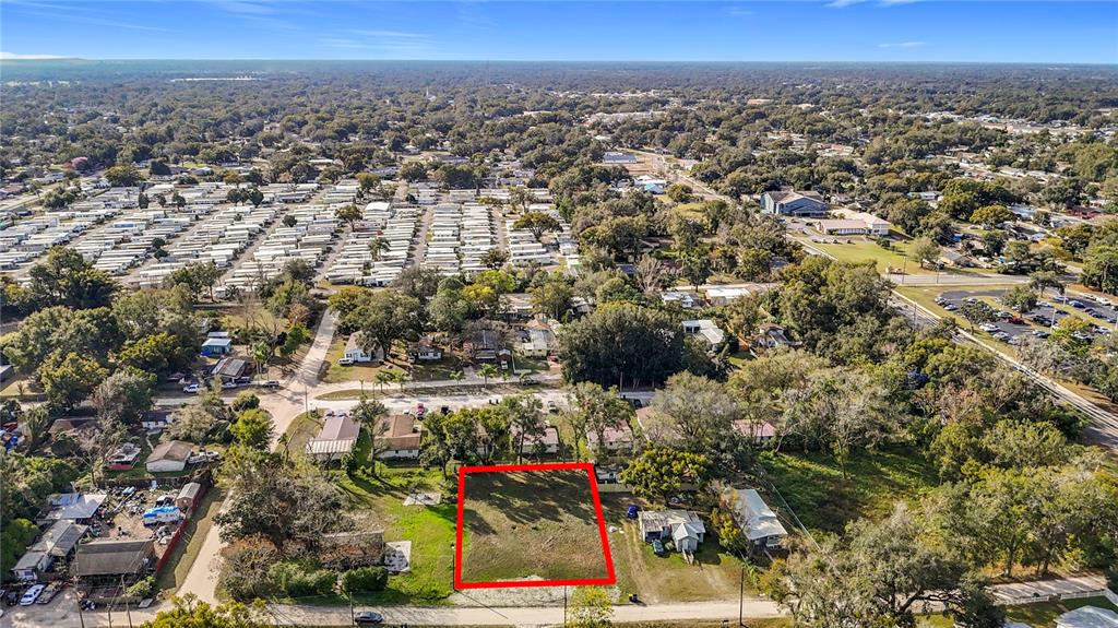 An aerial view shows a vacant rectangular lot outlined in red within a residential area — 38548 CALUMET AVENUE, ZEPHYRHILLS, FL