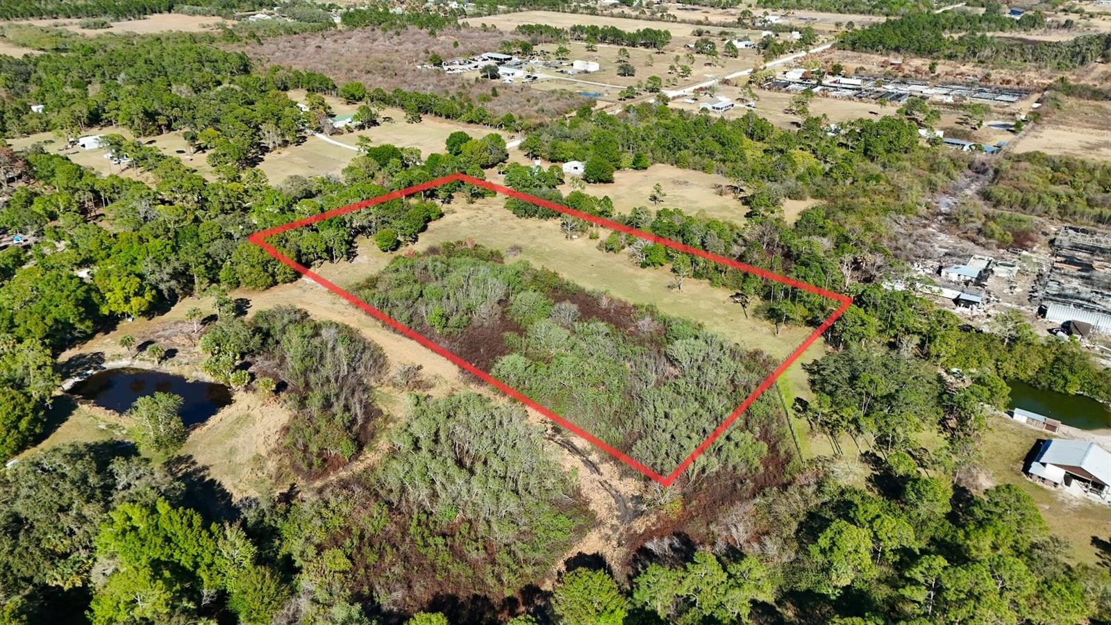 An aerial view shows a rectangular plot of land outlined in red amidst wooded surroundings — 13822 Hamlin Avenue, Clewiston FL 33440, CLEWISTON, FL