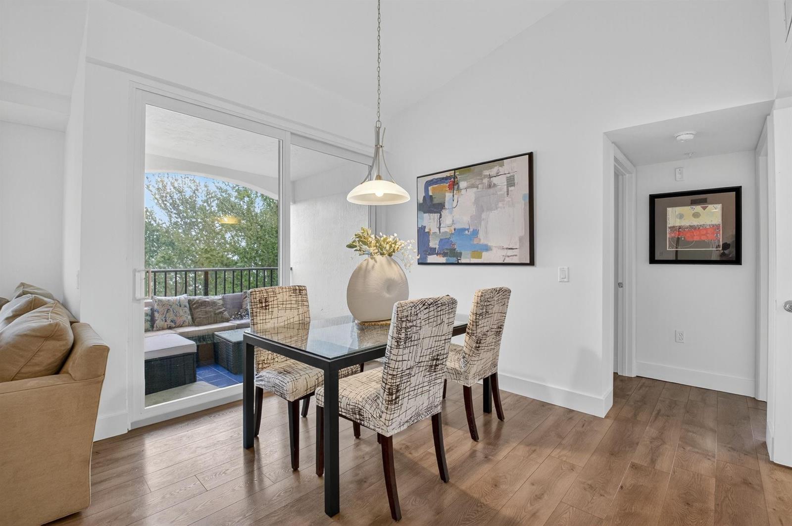 A dining area with a glass table, patterned chairs, and a sliding door to a balcony — 224 Villa Circle # 224, Boynton Beach FL 33435, BOYNTON BEACH, FL