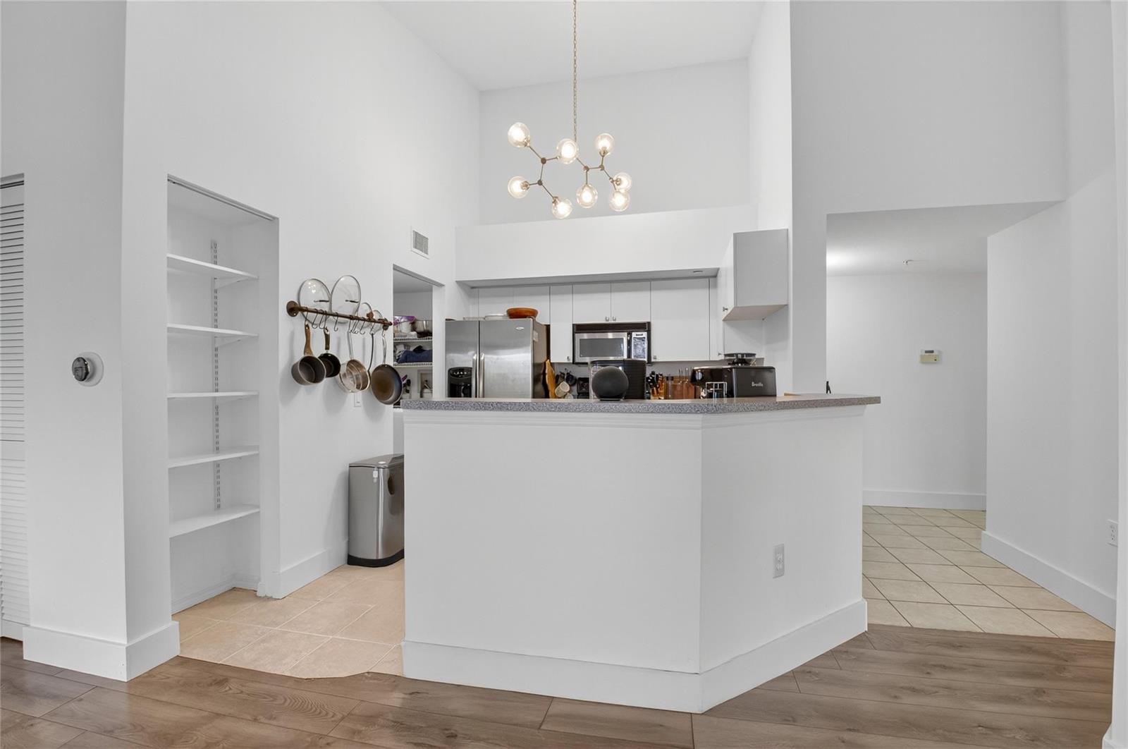 A kitchen with white cabinets, a breakfast bar, and a hanging light fixture — 224 Villa Circle # 224, Boynton Beach FL 33435, BOYNTON BEACH, FL