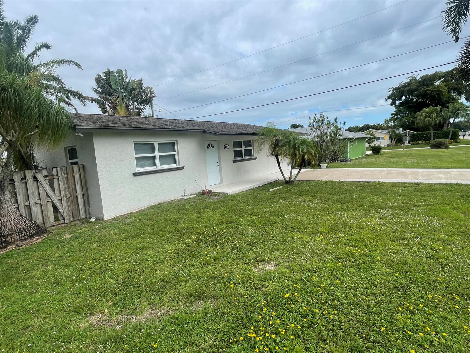 A single-story house with a white exterior, a front door, and a grassy yard — 4779 Bonanza Road, Lake Worth FL 33467, LAKE WORTH, FL