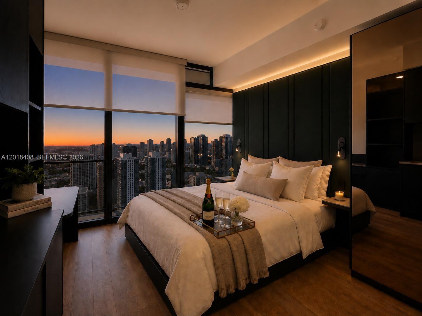 A modern bedroom features a bed with a champagne tray, dark wall paneling, and city views — 20 NE 11th # 4203A, Miami FL 33132, MIAMI, FL