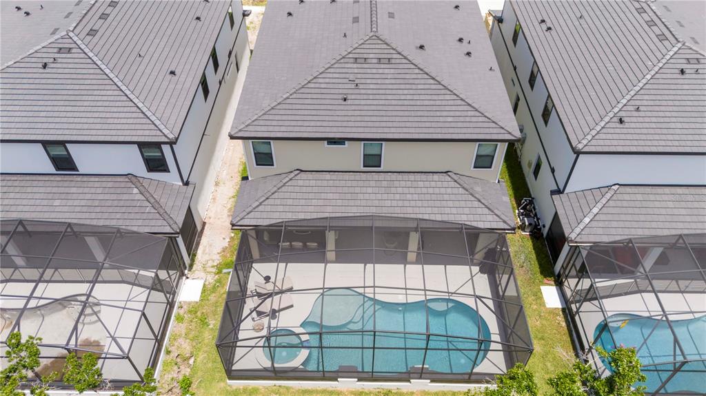 An aerial view shows a house with a screened-in pool and spa in the backyard — 5887 HIGH SEAS DRIVE, ORLANDO, FL