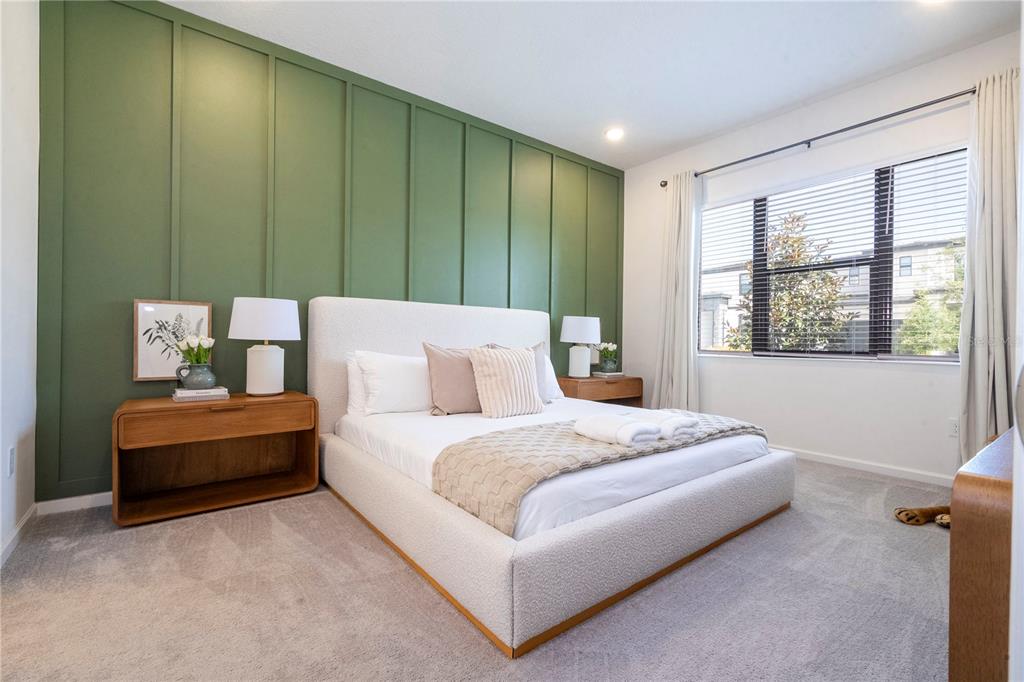 A bedroom features a green board-and-batten accent wall, a white upholstered bed, and wood nightstands — 5887 HIGH SEAS DRIVE, ORLANDO, FL