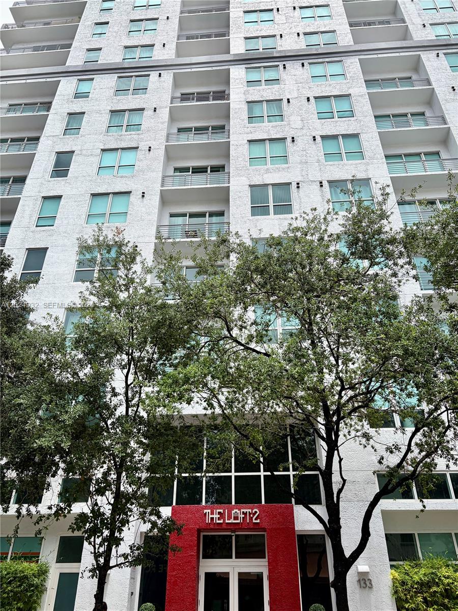 A modern kitchen features white cabinetry, a black ceiling, and a dining table with chairs — 133 NE 2nd Ave # 1909, Miami FL 33132, MIAMI, FL
