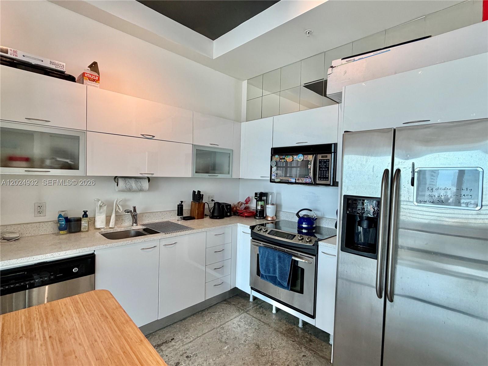 A modern kitchen features white cabinets, stainless steel appliances, and a countertop with a sink — 133 NE 2nd Ave # 1909, Miami FL 33132, MIAMI, FL