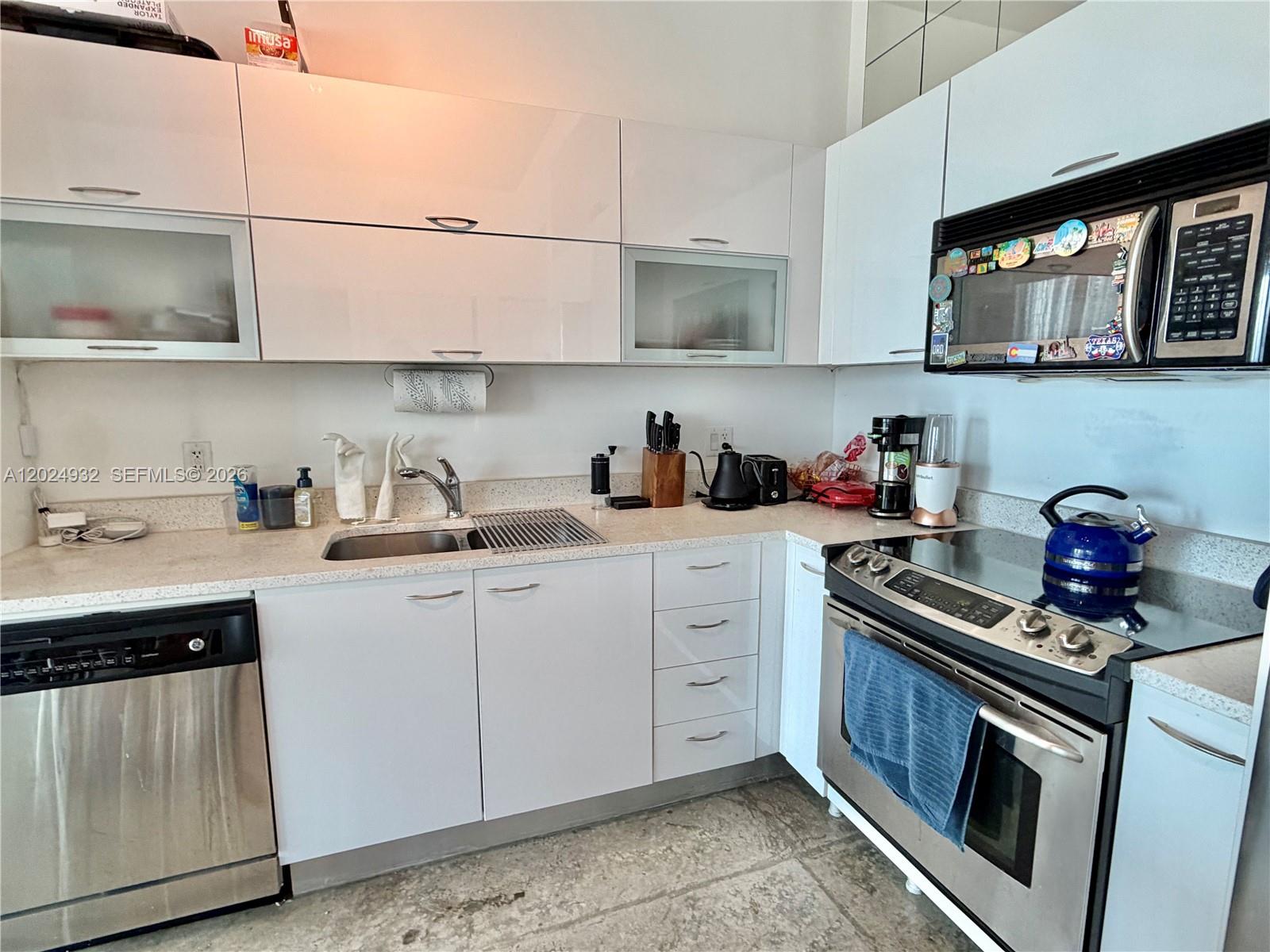 A living room features a grey sofa, a round coffee table, and a city balcony — 133 NE 2nd Ave # 1909, Miami FL 33132, MIAMI, FL