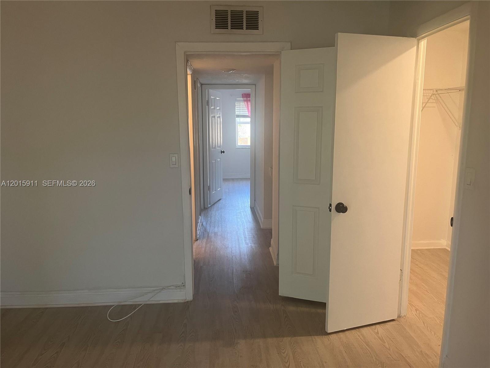 A hallway with light wood-look flooring connects two rooms, with an open closet door visible — 5952 NW 25th Pl # 234, Sunrise FL 33313, SUNRISE, FL
