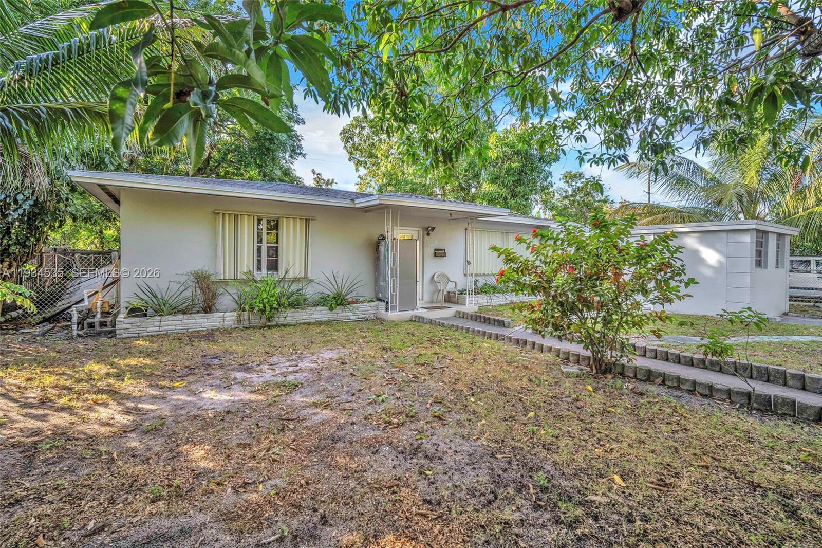 A single-story house with a white exterior, a front walkway, and mature trees — 16234 NE 9th Ct, North Miami Beach FL 33162, NORTH MIAMI BEACH, FL