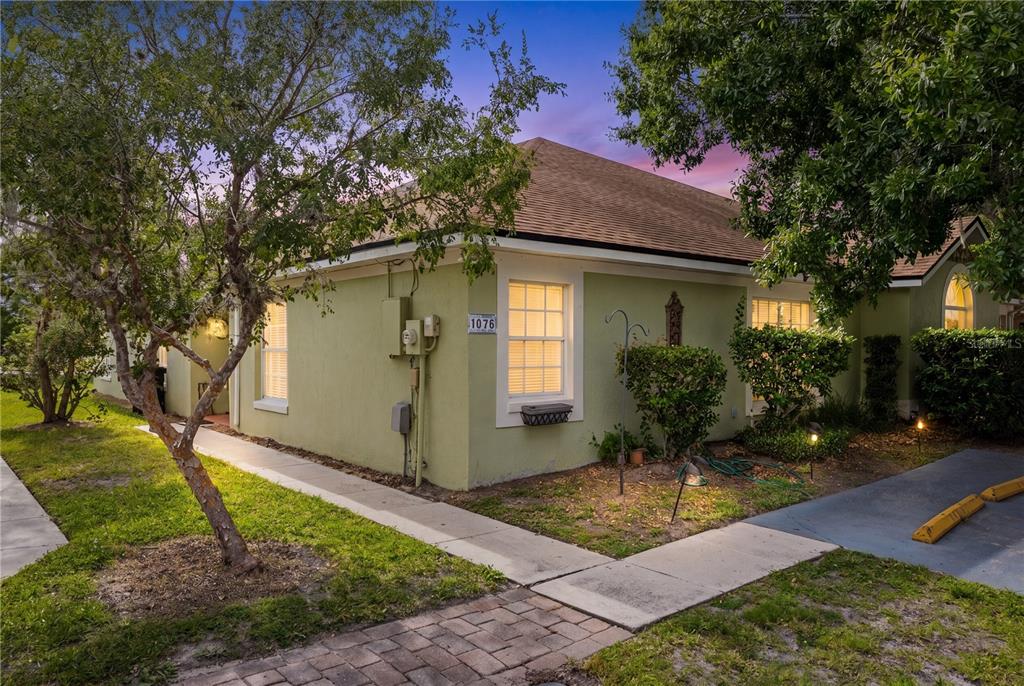 A light green exterior wall of a house features a window with a house number — 1076 UNIVERSAL REST PLACE, KISSIMMEE, FL