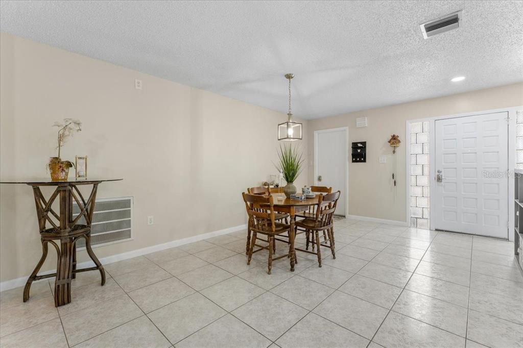 A dining area features tile flooring, a round wooden table with chairs, and a glass-topped table — 344 CROSSWINDS DRIVE, PALM HARBOR, FL