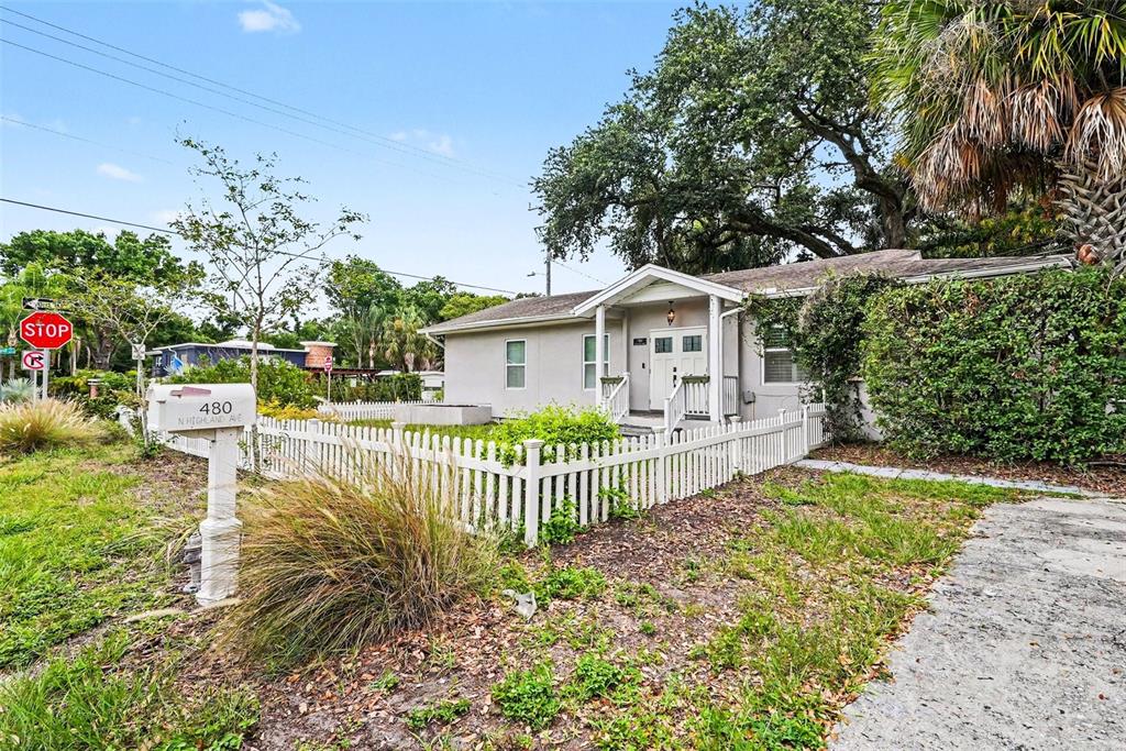 A light-colored single-story house with a white picket fence and a large oak tree — 4809 N HIGHLAND AVENUE, TAMPA, FL