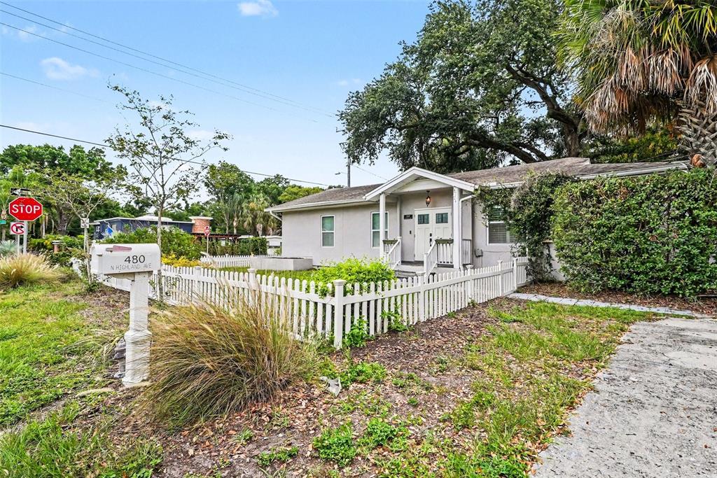 A single-story house with a white picket fence and a mailbox stands on a corner — 4809 N HIGHLAND AVENUE, TAMPA, FL