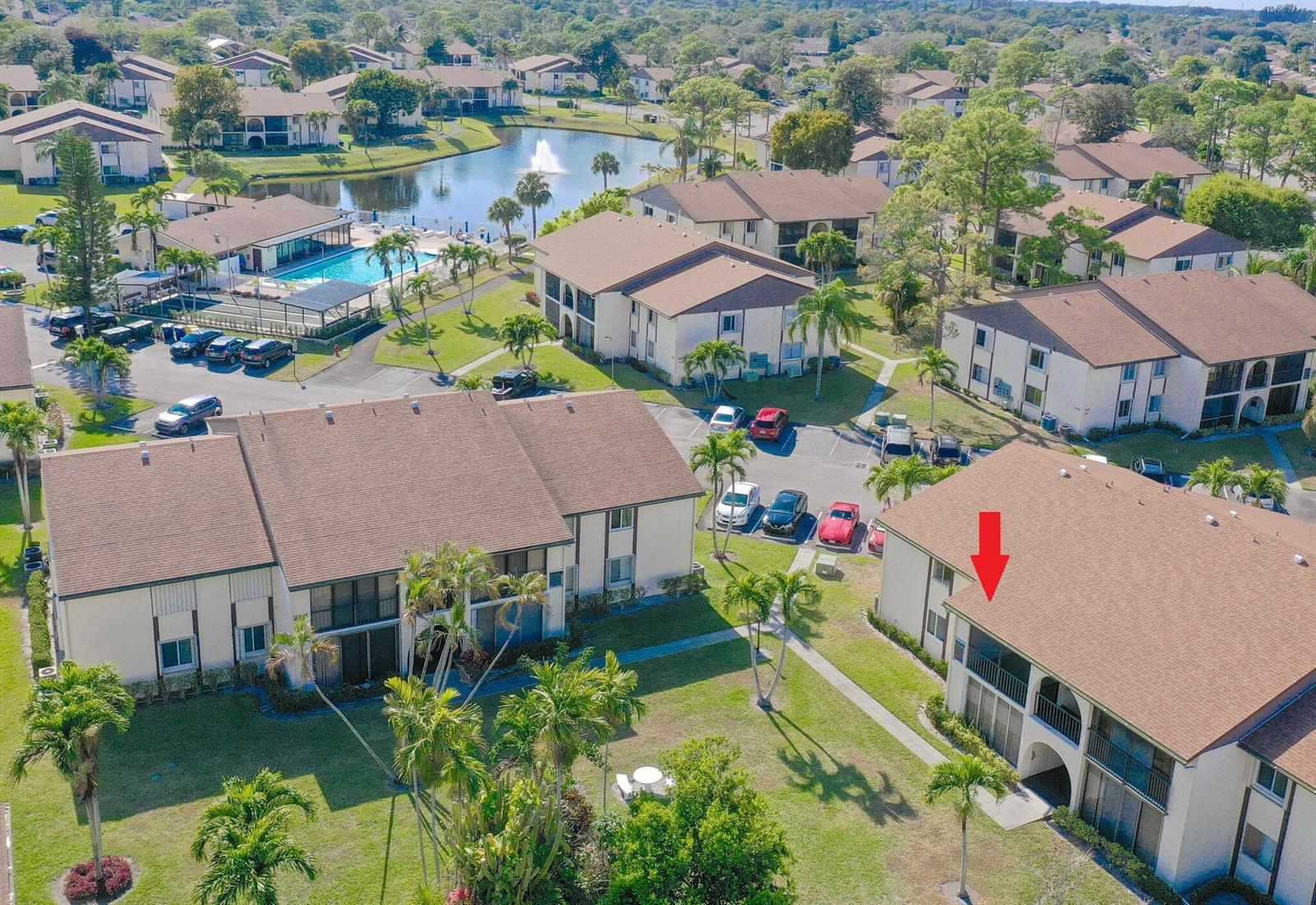 An aerial view shows multi-story apartment buildings with brown roofs, a swimming pool, and parking — 3530 Pine Needle Drive # 2, FL 33463, FL