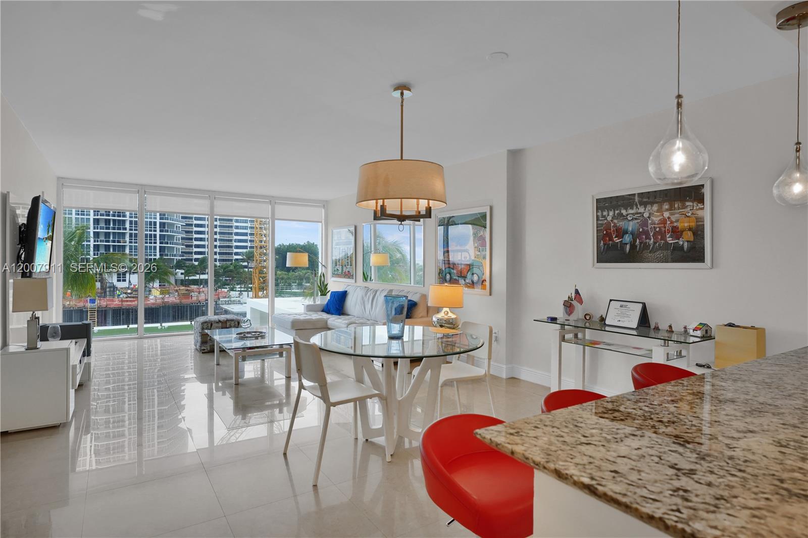 A bright, open-concept living and dining area features tile floors, a glass table, and floor-to-ceiling windows — 10275 Collins Ave # 315, Bal Harbour FL 33154, BAL HARBOUR, FL