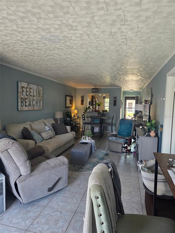 A living room features a sofa, recliner, dining area, and tiled floors under a textured ceiling — 13830 MISSION OAKS BOULEVARD UNIT 13830, SEMINOLE, FL