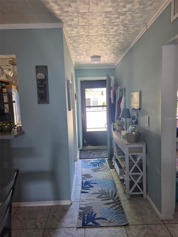 A hallway with light blue walls, a patterned ceiling, and a runner rug leads outside — 13830 MISSION OAKS BOULEVARD UNIT 13830, SEMINOLE, FL