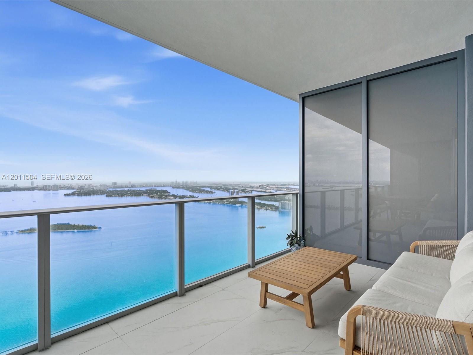 A balcony with a glass railing overlooks a bay with islands under a blue sky — 700 NE 24th Street # 4606, Miami FL 33137, MIAMI, FL