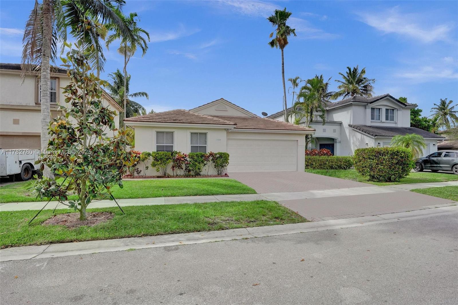 A single-story house with a beige exterior, a two-car garage, and a paved driveway — 7324 NW 1st Pl, Plantation FL 33317, PLANTATION, FL