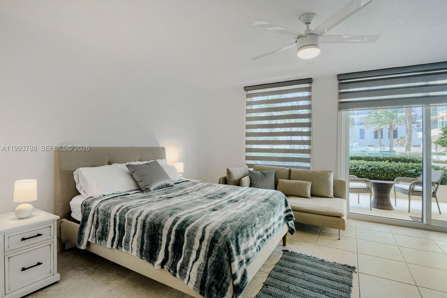 A bedroom features a bed, a small sofa, a ceiling fan, and a sliding glass door — 2501 S Ocean Dr, Hollywood FL 33019, HOLLYWOOD, FL