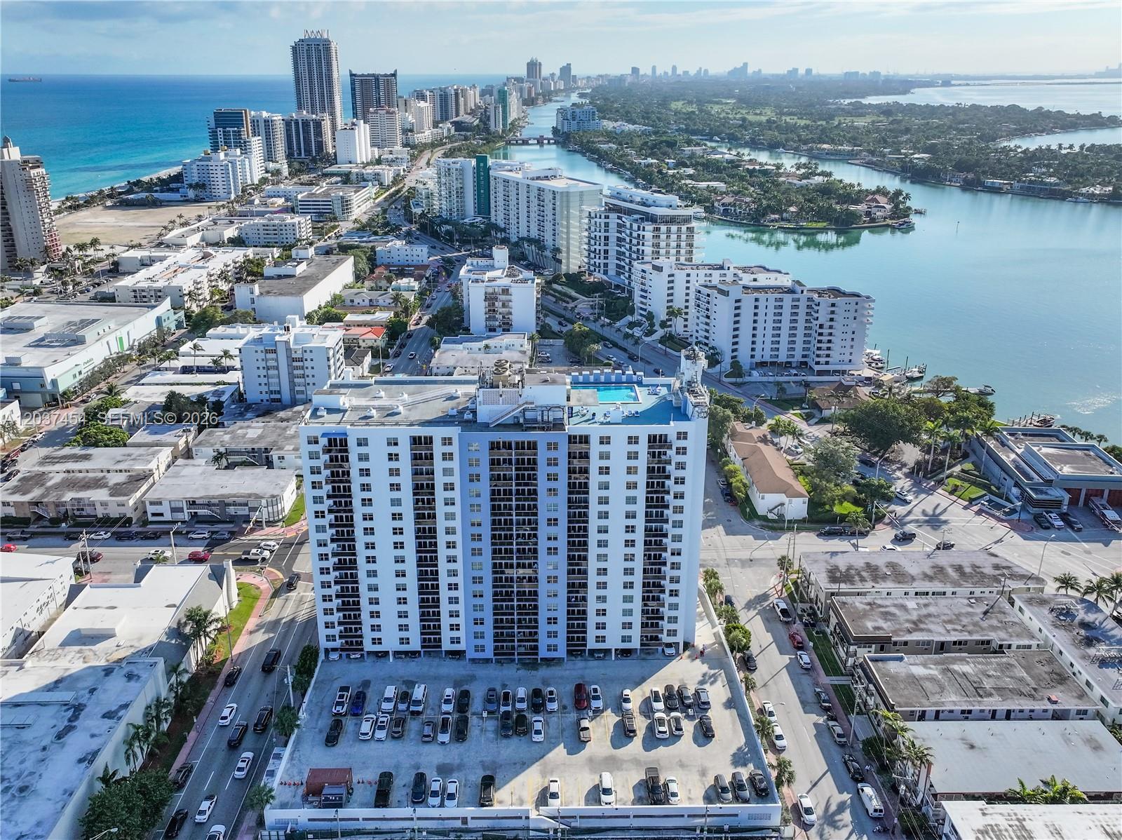 An aerial view shows a high-rise residential building with a rooftop pool and parking lot — 401 69th St # 313, Miami Beach FL 33141, MIAMI BEACH, FL