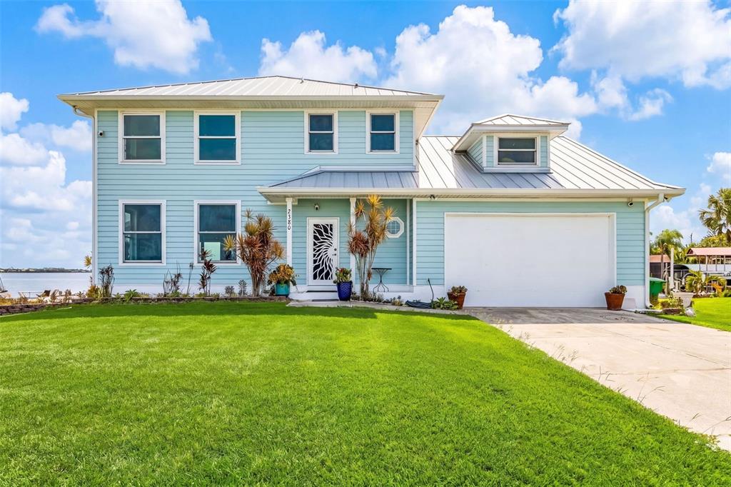 A two-story light blue house with a metal roof and an attached two-car garage — 2380 VANCE TERRACE, PORT CHARLOTTE, FL