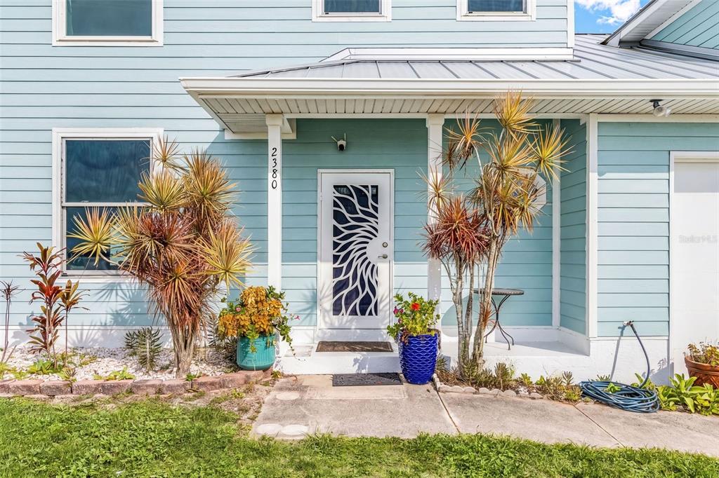 The exterior of a light blue house features a front porch with tropical plants — 2380 VANCE TERRACE, PORT CHARLOTTE, FL